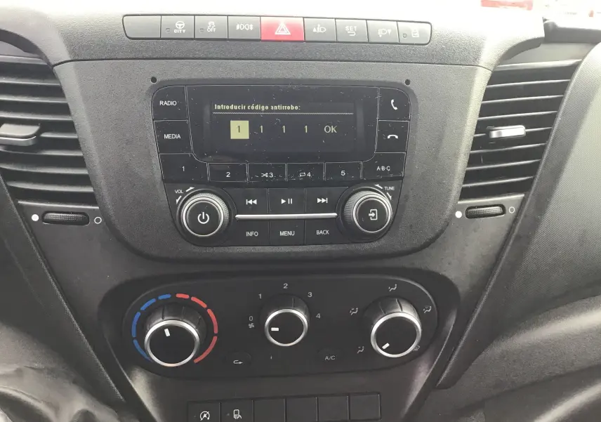 Tableau de bord central du fourgon Iveco Daily blanc 2022 avec commandes radio et climatisation visibles.