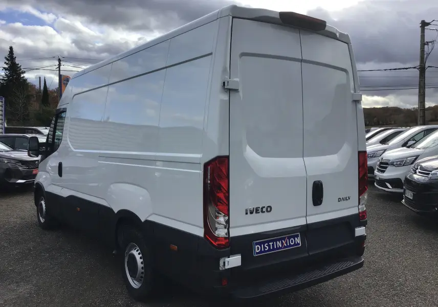 Fourgon blanc Iveco Daily 2022 vu en 3/4 arrière droit, avec portes arrière fermées et marchepied noir visible.