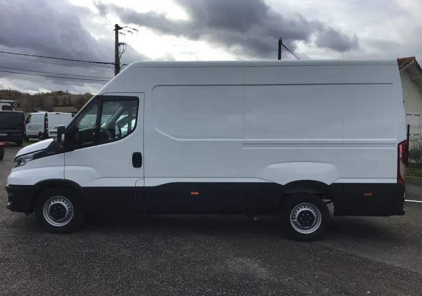 Profil latéral gauche d'un fourgon Iveco Daily blanc 2022 avec marchepied arrière et partie inférieure noire.