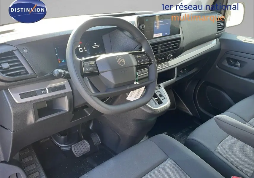 Vue intérieure côté conducteur du Citroën Jumpy Fourgon XL 2025, tableau de bord moderne avec volant multifonction et sièges gris.