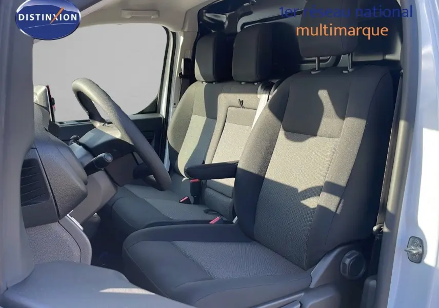 Vue intérieure côté conducteur du Citroën Jumpy Fourgon XL 2025, sièges tissu gris noir et volant multifonction.