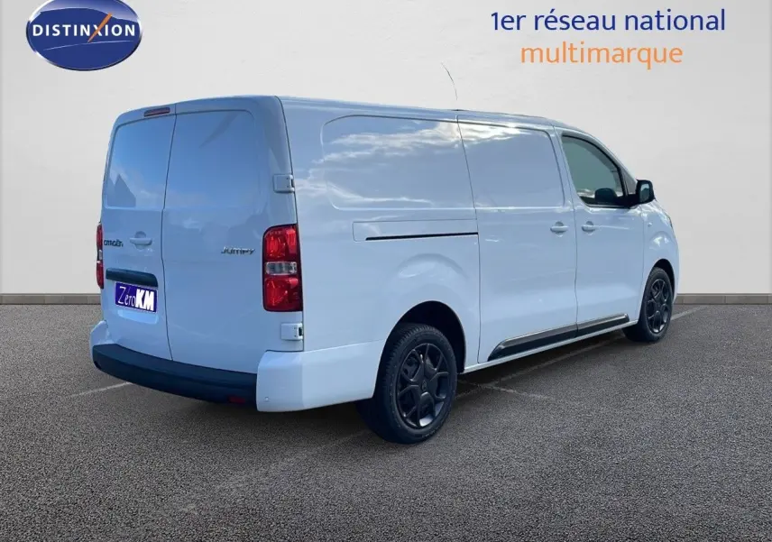 Vue 3/4 arrière droite du Citroën Jumpy Fourgon XL blanc Kaolin avec jantes noires et portes latérales fermées.