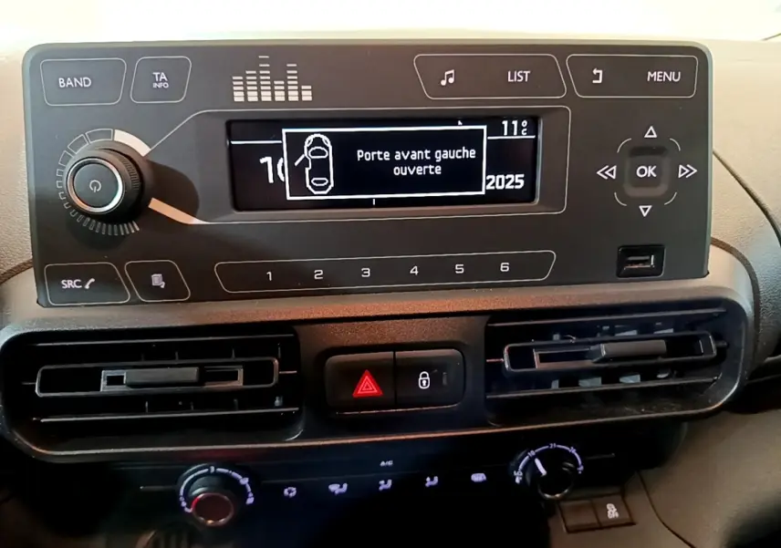 Tableau de bord noir du Citroën Berlingo 2021 avec écran central indiquant porte avant gauche ouverte.