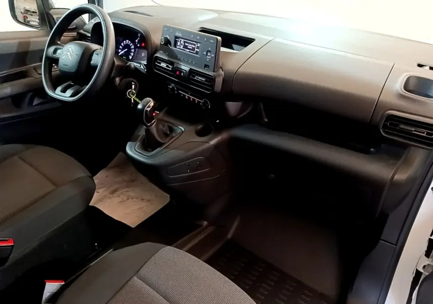 Vue intérieure côté conducteur du Citroën Berlingo blanc 2021, tableau de bord avec écran tactile et volant multifonction.
