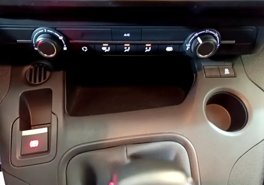 Vue rapprochée de la console centrale noire du Citroën Berlingo 2021 avec commandes climatisation et frein à main électrique.