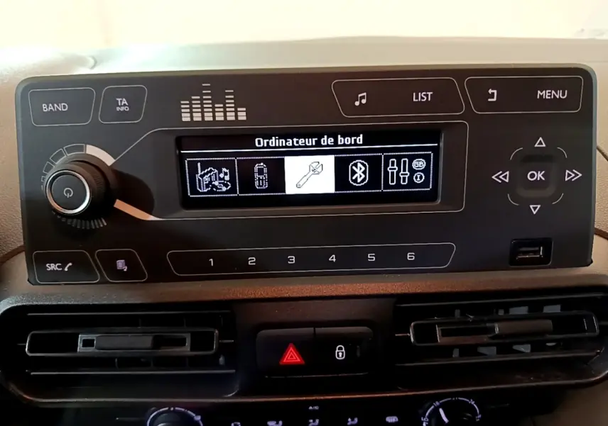 Tableau de bord du Citroën Berlingo 2021, affichage numérique central avec commandes audio et climatisation visibles.