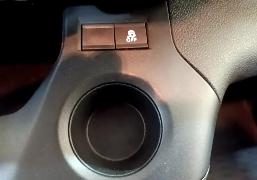 Gros plan sur le bouton de contrôle de l'antipatinage noir dans l'habitacle du Citroën Berlingo blanc.