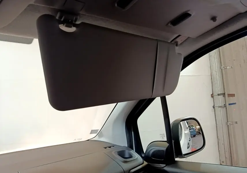 Intérieur du Citroën Berlingo 2021, vue côté passager avec pare-soleil baissé et rétroviseur extérieur visible.