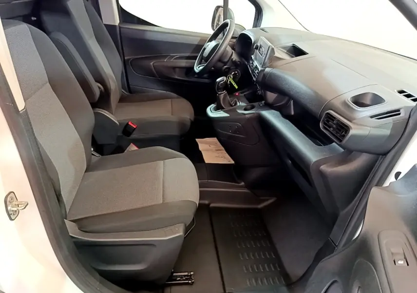 Intérieur avant du Citroën Berlingo blanc 2021, sièges gris et tableau de bord avec console centrale visible.