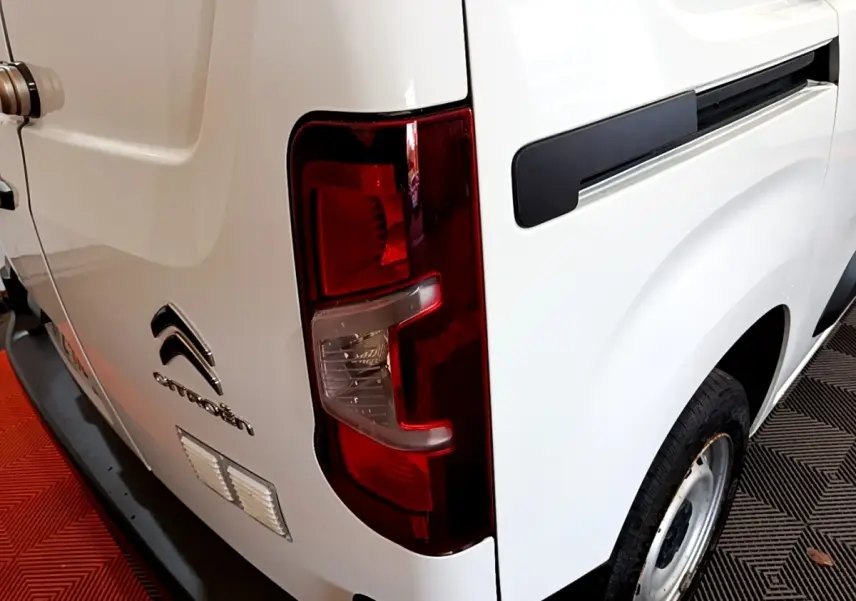 Vue arrière droite d'un utilitaire Citroën Berlingo blanc avec feu arrière rouge et jante acier simple.
