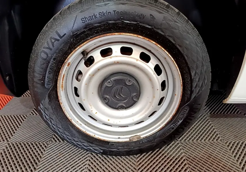 Gros plan sur la roue acier blanche rouillée côté avant droit du Citroën Berlingo blanc 2021 M 650kg BlueHDi.