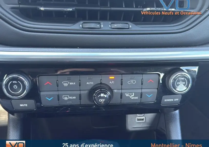 Vue rapprochée du tableau de bord noir du Jeep Compass 2024 avec commandes de climatisation et port USB visible.