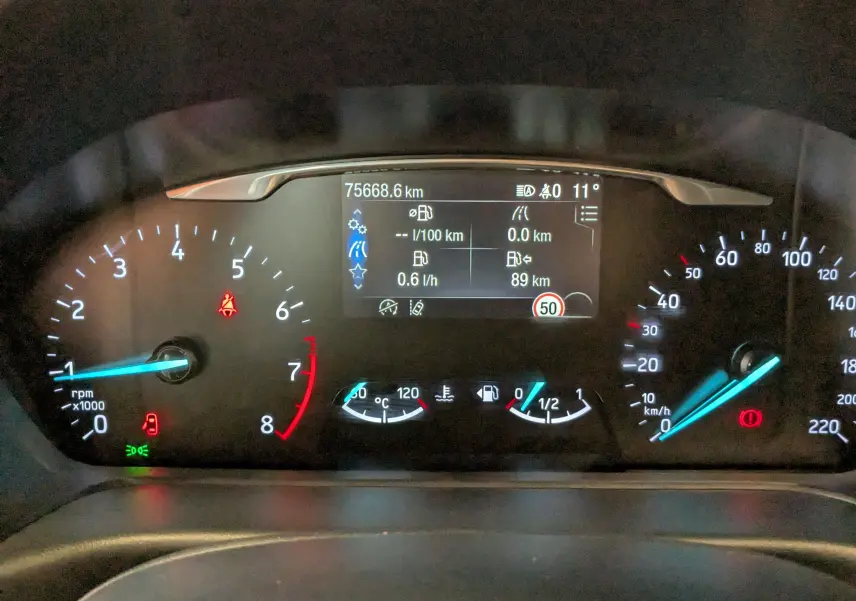 Vue rapprochée du tableau de bord numérique du Ford Puma gris, affichant les compteurs et informations de conduite.