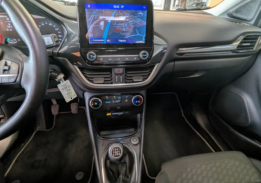 Vue intérieure du tableau de bord du Ford Puma gris 2020, avec écran tactile central, climatisation et boîte manuelle.