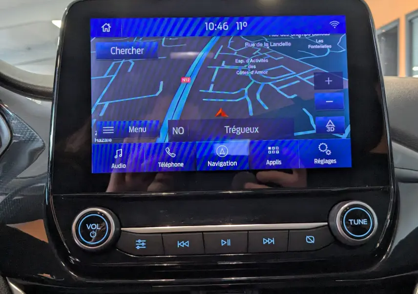 Écran tactile central de la Ford Puma 2020 gris, affichant la navigation GPS avec commandes audio et téléphone.