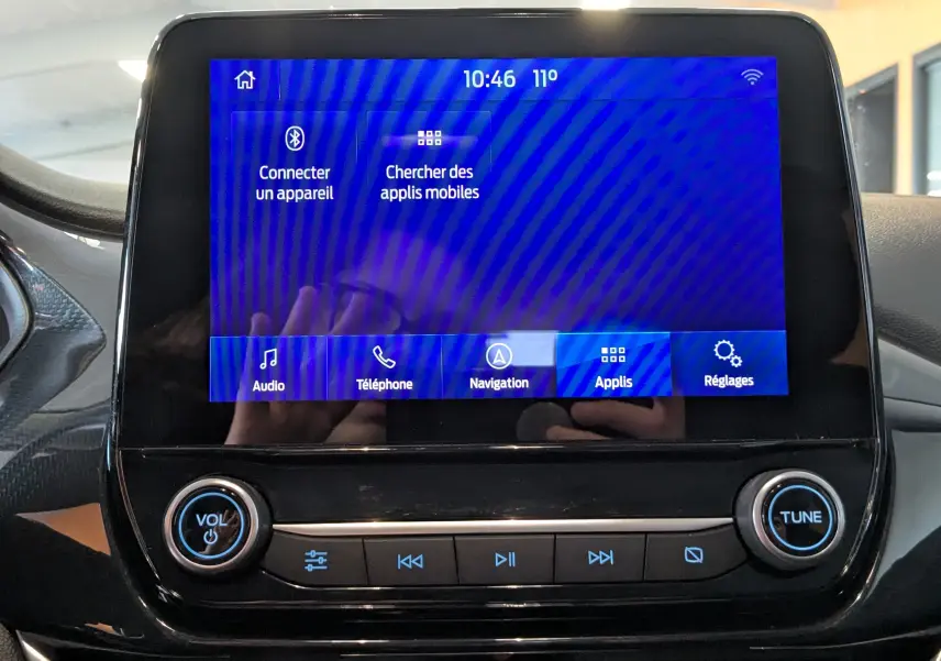 Écran tactile central de la Ford Puma 2020 gris, affichant le menu principal avec options audio, téléphone et navigation.
