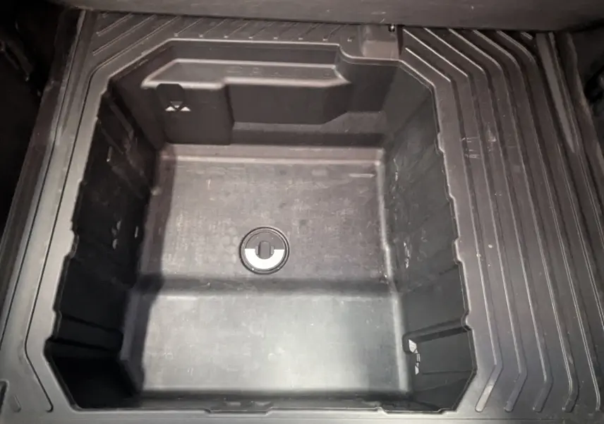 Coffre de rangement vide en plastique noir, vue plongeante, intérieur du Ford Puma gris 2020.