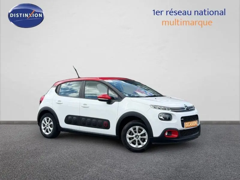 Vue 3/4 avant droite d'une Citroën C3 PureTech 82ch Feel blanche Banquise avec toit et détails rouges Aden, équipée d'Airbump noirs.