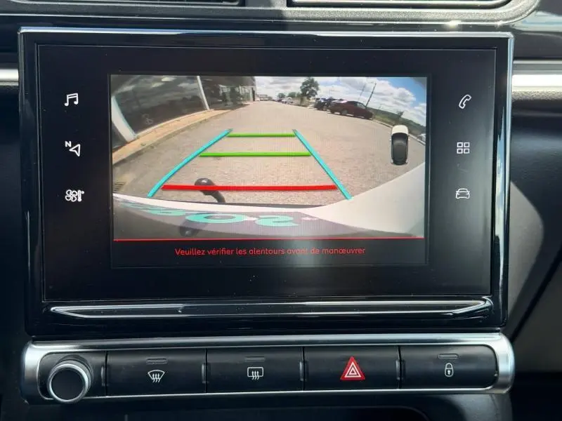 Vue arrière via caméra de recul sur écran intérieur d'une Citroën C3 PureTech 82ch Feel blanc Banquise avec repères colorés de guidage.