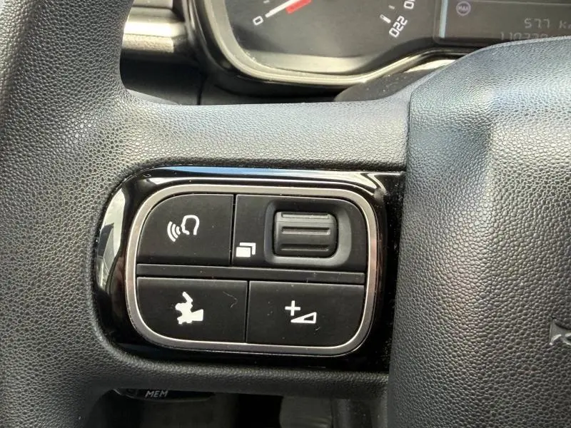 Gros plan sur les commandes multifonctions noires du volant d'une Citroën C3 PureTech 82ch Feel 2017.