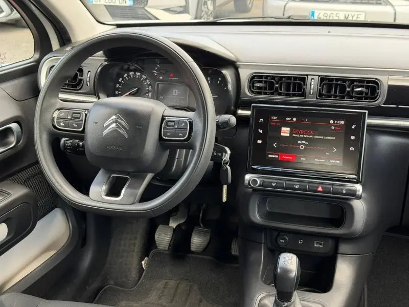 Vue intérieure du poste de conduite de la Citroën C3 PureTech 82ch Feel, avec volant multifonction et écran tactile central.