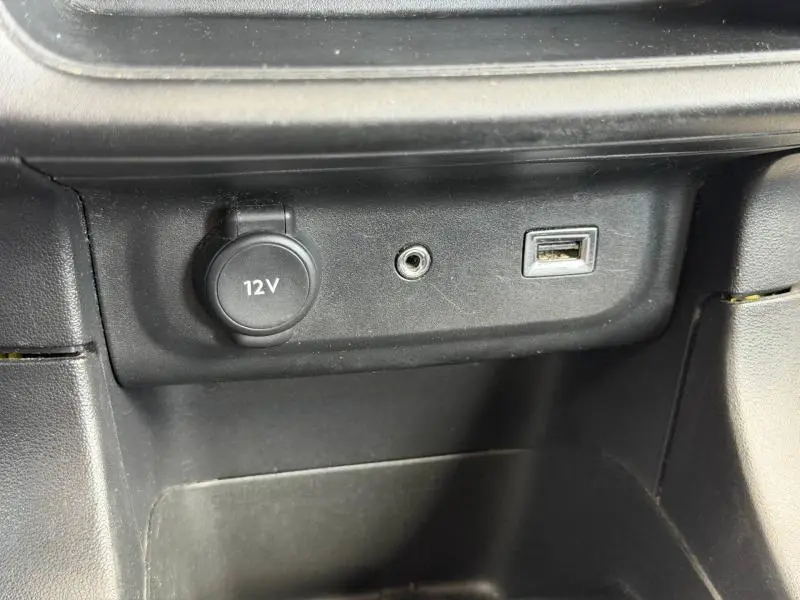 Prise 12V, entrée auxiliaire et port USB sur la console centrale noire d'une Citroën C3 PureTech 82ch Feel 2017.