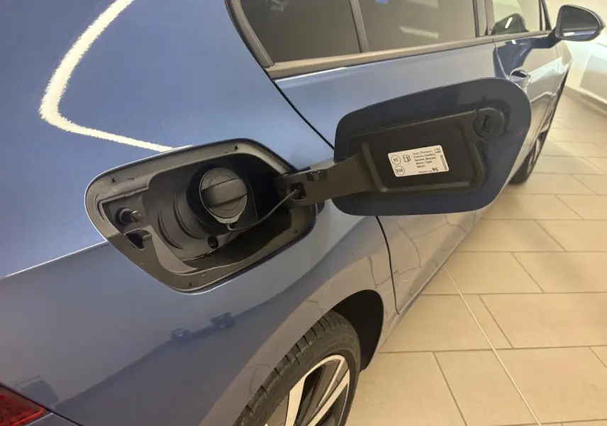 Vue arrière côté gauche d'une Volkswagen Golf Bleu Anémone avec trappe à carburant ouverte et jante alliage 18 pouces.