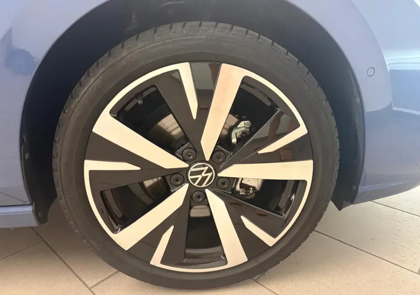 Gros plan sur la jante alliage 18'' Catania bicolore noir et argent d'une Volkswagen Golf Bleu Anémone côté arrière droit.