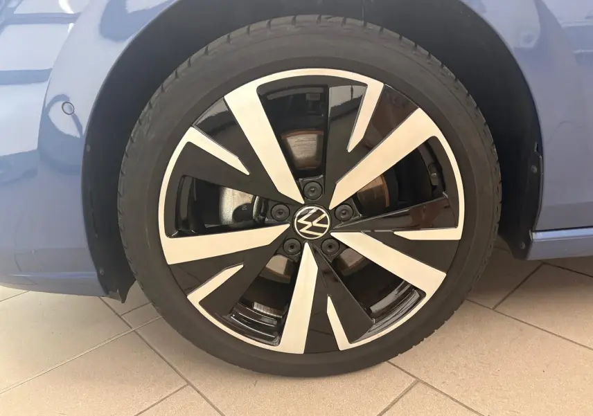 Gros plan sur la jante alliage 18'' Catania bicolore noir et argent d'une Volkswagen Golf Bleu Anémone.