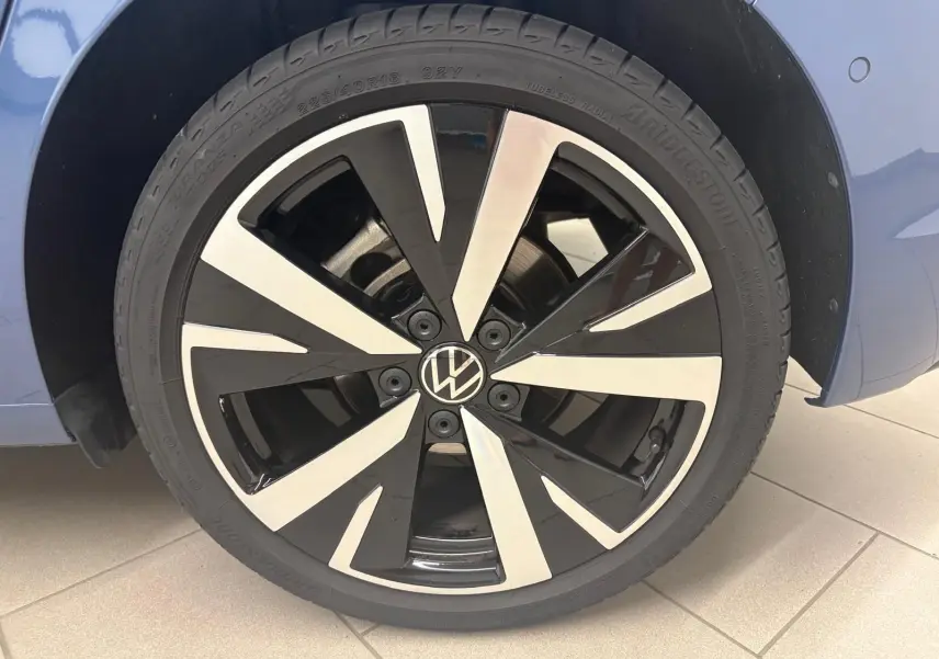 Gros plan sur la jante alliage 18'' Catania bicolore noir et argent de la Volkswagen Golf Bleu Anémone, côté gauche.