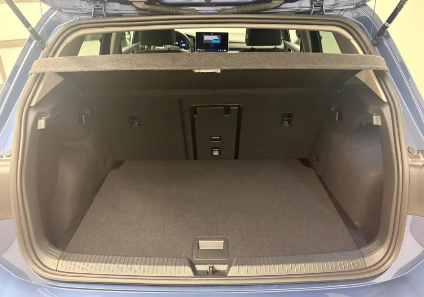 Coffre ouvert vu de l'arrière d'une Volkswagen Golf Bleu Anémone, montrant l'espace de chargement et la tablette arrière.