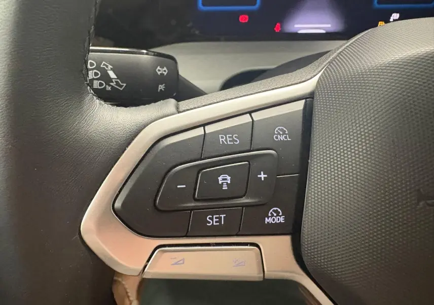 Gros plan sur les commandes du volant côté gauche de la Volkswagen Golf 1.5 TSI 116 BVM6 Bleu Anémone, 2025.