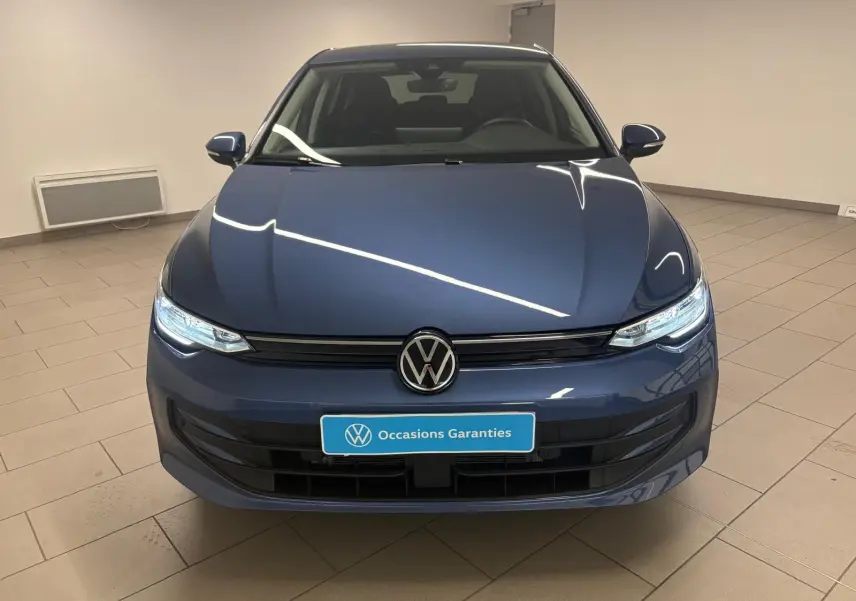 Volkswagen Golf 1.5 TSI bleu Anémone vue de face, avec phares allumés et calandre noire brillante.