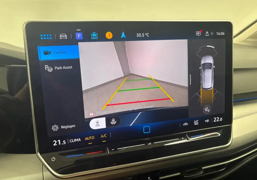 Écran tactile intérieur de Volkswagen Golf 2025 montrant l'assistance au stationnement avec caméra de recul active.