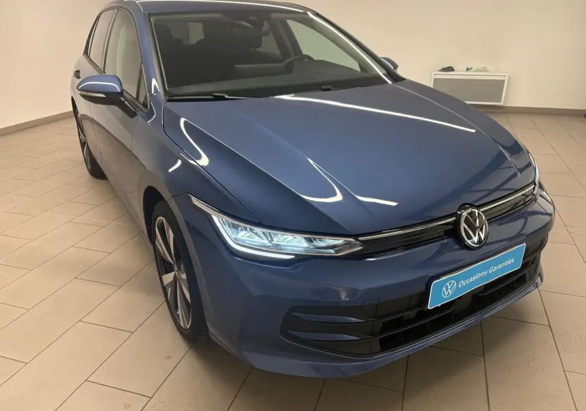 Volkswagen Golf 1.5 TSI Bleu Anémone vue 3/4 avant avec jantes alliage 18'' Catania en intérieur showroom.