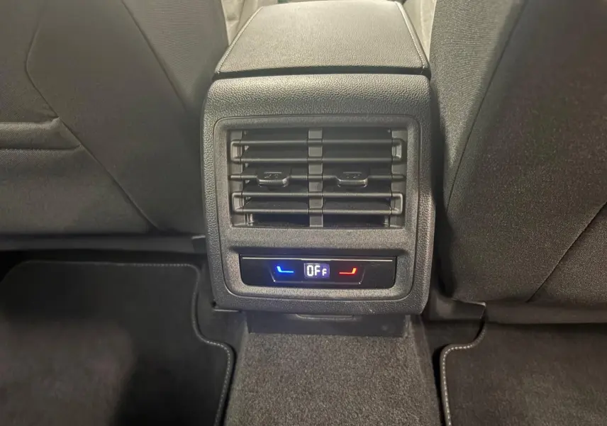 Détail de la console arrière avec diffuseurs d'air et commandes de climatisation, intérieur tissu noir.