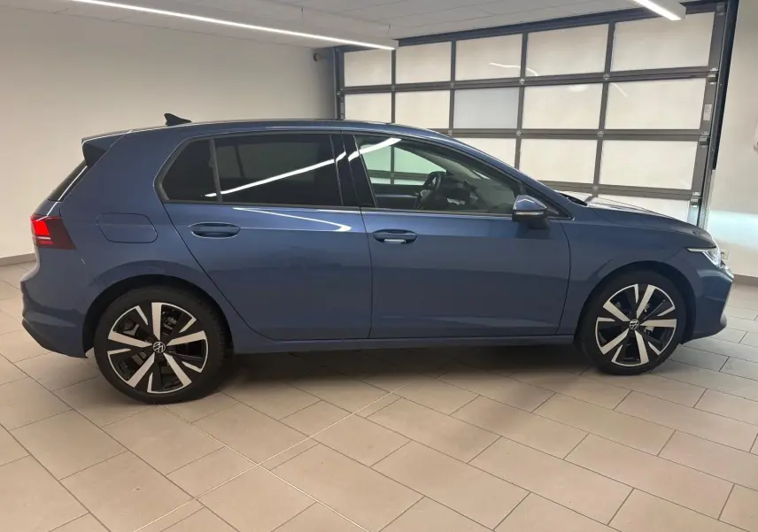 Profil droit d'une Volkswagen Golf 1.5 TSI 2025 en bleu Anémone avec jantes alliage léger 18'' Catania.