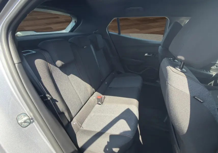 Vue intérieure côté arrière droit du Peugeot 2008 Hybrid 145 gris clair, montrant la banquette arrière en tissu.