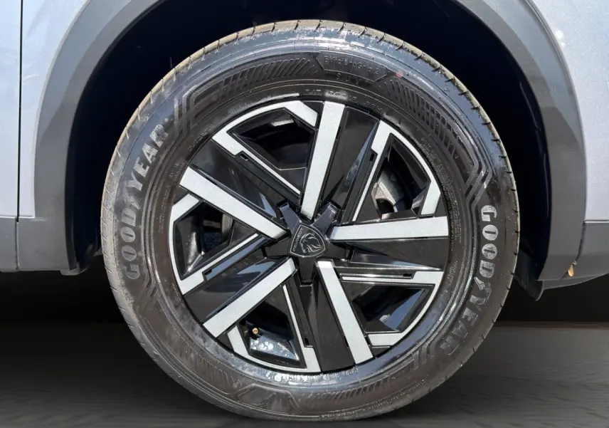 Gros plan sur la roue avant droite gris clair du Peugeot 2008 Hybrid 145 e-DCS6 STYLE avec jante noire et argentée.