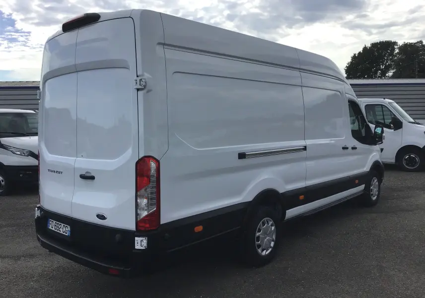 Ford Transit Fourgon blanc vu en 3/4 arrière droit, avec porte arrière fermée et feux rouges verticaux.