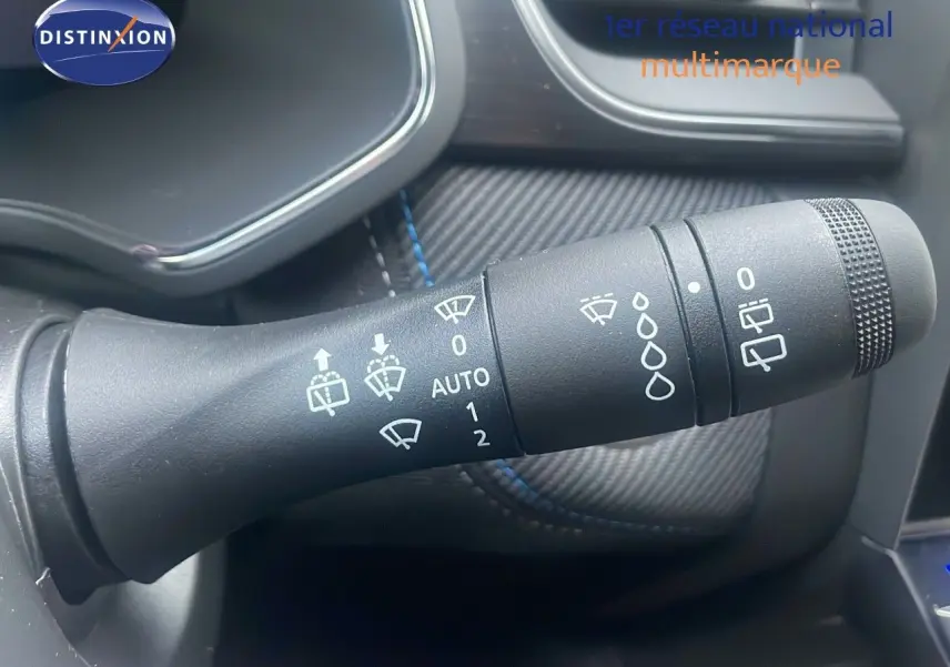 Gros plan sur la commande des essuie-glaces du Renault Captur E-Tech hybride 2025, intérieur noir avec surpiqûres bleues.
