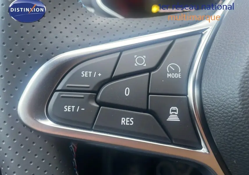 Gros plan sur les commandes au volant du Renault Captur E-Tech hybride 2025, avec finition cuir perforé noir.