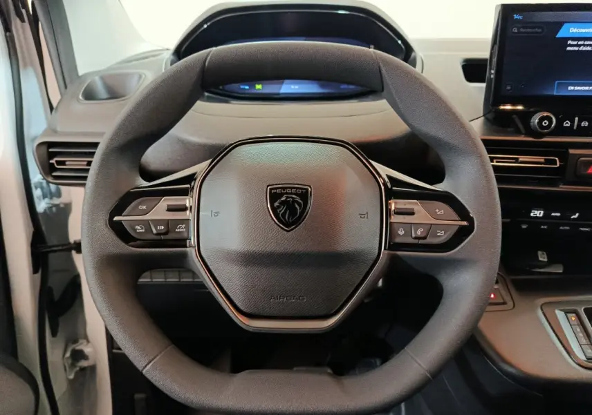 Vue rapprochée du volant multifonction noir du Peugeot Partner XL 2025 avec tableau de bord numérique et écran tactile.