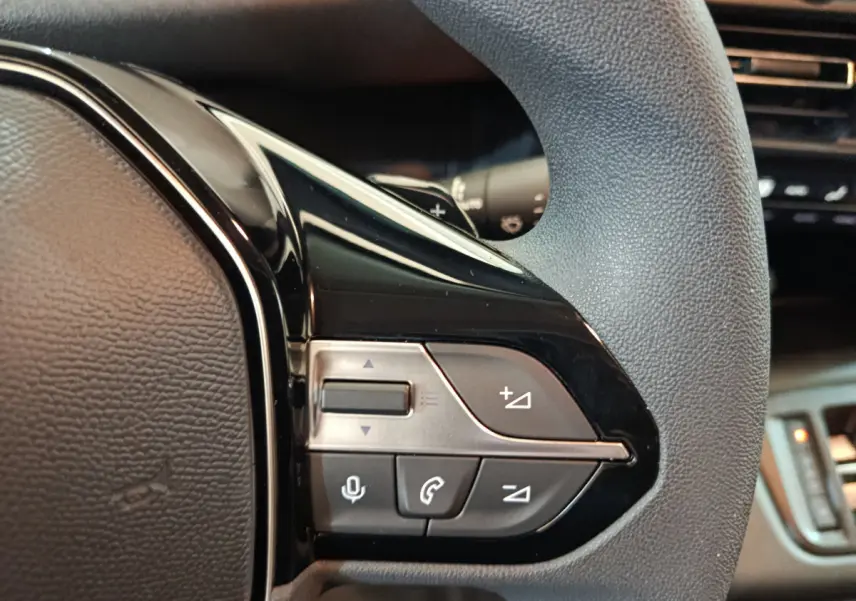 Gros plan sur les commandes multifonctions noires du volant du Peugeot Partner XL blanc 2025.