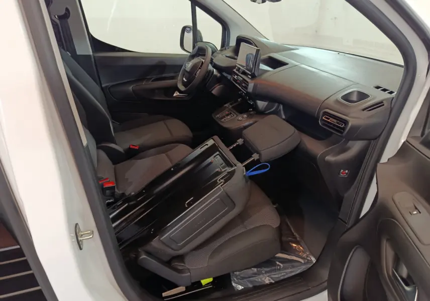 Intérieur du Peugeot Partner XL blanc 2025 vu côté conducteur, montrant sièges noirs et tableau de bord moderne.