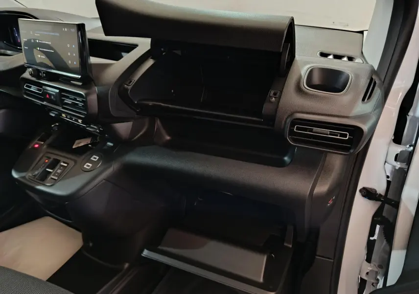 Vue intérieure côté passager du tableau de bord noir du Peugeot Partner XL 2025 avec boîte à gants ouverte et écran tactile central.