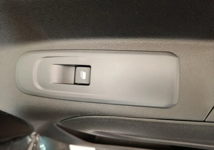 Gros plan sur le bouton de commande de la vitre électrique côté conducteur du Peugeot Partner XL blanc 2025.