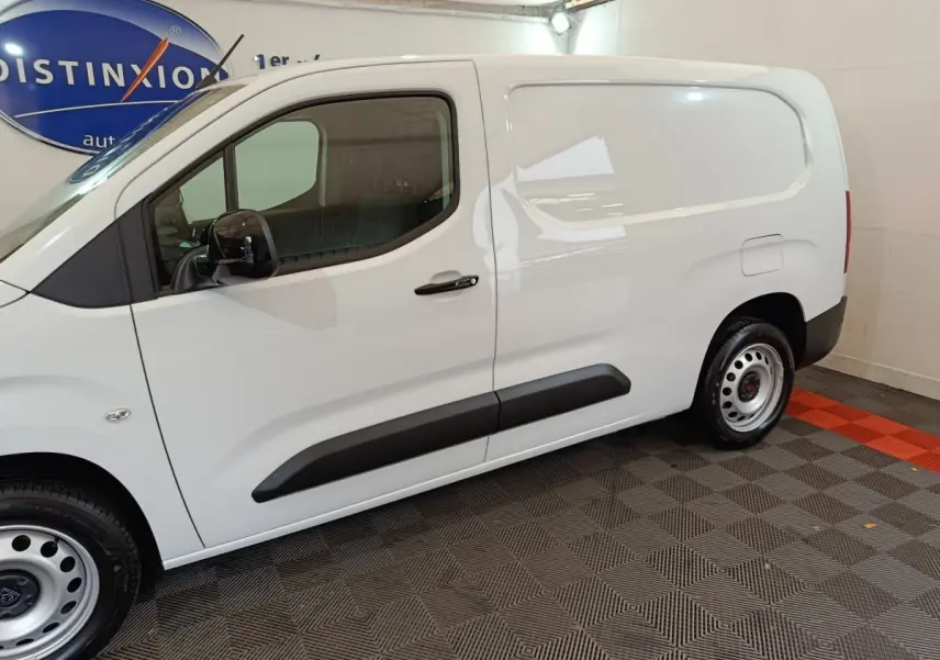 Vue de profil côté gauche d'un utilitaire blanc Peugeot Partner XL 950kg avec portes latérales pleines et jantes acier.