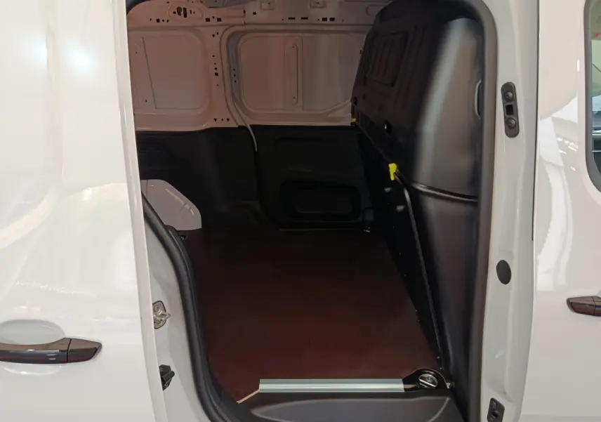 Vue intérieure du coffre côté droit d'un Peugeot Partner XL blanc, montrant l'espace de chargement vide et la cloison pleine noire.