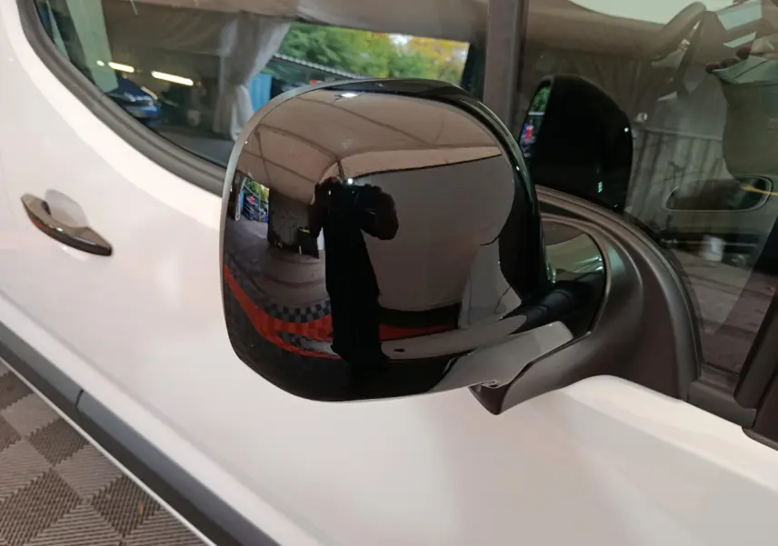 Rétroviseur noir côté conducteur du Peugeot Partner XL blanc 2025, vue rapprochée sur la portière avant.